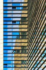 Architectual view of a glass building with straight lines making reflections