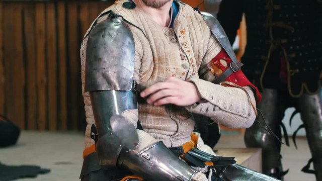 Knights training - men putting on a full armour before a training fight