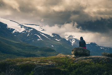 Girl sitting and watching the mountains