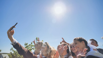 Happy high school graduates take a selfie on a sunny day. © Довидович Михаил