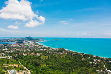 Fototapeta na wymiar Aerial scenery view of white sand shore with turquoise clear sea water. Bird's eye panoramic view of picturesque lagoon with hotels on beach. Populated island in Thailand
