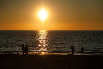 Rowy/Poland - June, 2019: People on the beach watching beaufiful sunset
