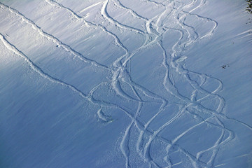 snowboard tracks on a snowy mountainside on sunset