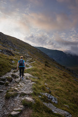 Young woman walking up mountain
