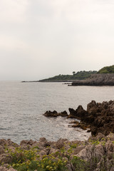 Rocky seashore under cloudy sky. Cap d'Antibes, Cote d'Azur, France. 