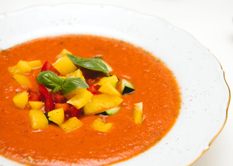 Side view of delicious homemade gazpacho in white bowl on a white table made from organic bio ingredients