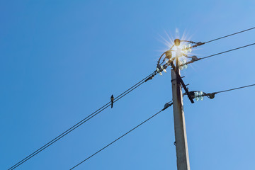 Fototapeta na wymiar High voltage transmission line pylons against a blue summer sky.
