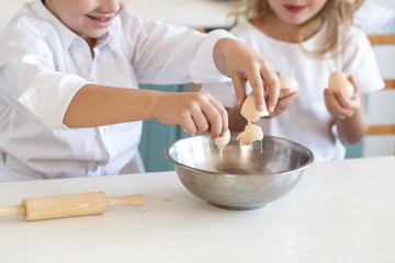 close up of children hands cooking with eggs