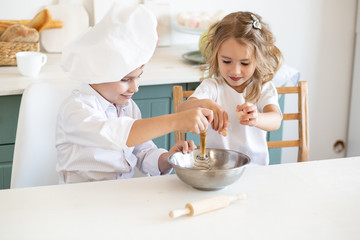 little children in the kitchen prepare food at home