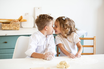 children kissing in the kitchen at home