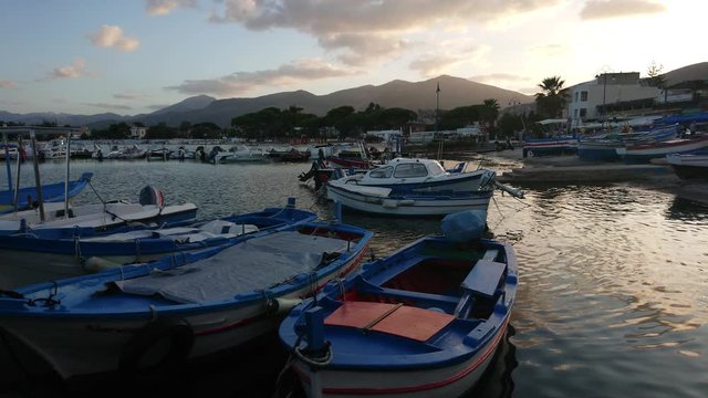 Beautiful sunset over mountains with fishing boats on foreground
