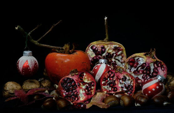 Red christmas balls amd autumn fruits on black background