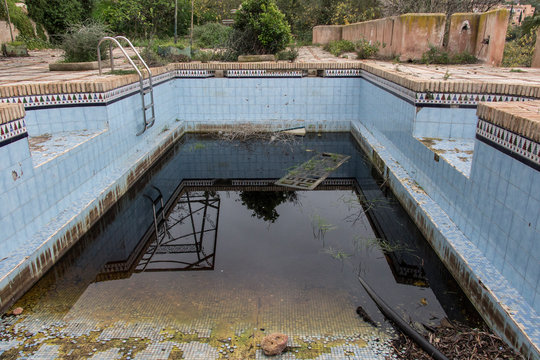 a dirty and abandoned pool with little water