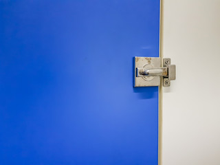 Colorful Toilet Door knob and lock inside office building, department store or public restroom. With copy space area to put text. Background interior wallpaper concept. Shade of light and shadow.