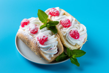 Cake with raspberries and sprinkles on a blue background