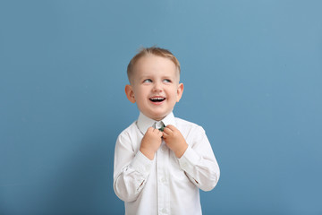 Portrait of stylish little boy on color background