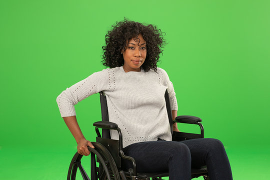 Charming portrait of happy African American woman sitting in wheelchair