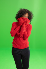 Cute African American woman in winter attire hides behind her scarf