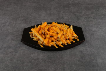 Cheesy fries - French fries with american cheese and cheddar cheese,  close-up on a plate. horizontal view from above