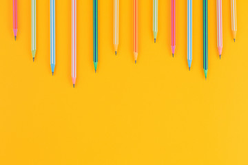 multicolored pencils on yellow isolated background