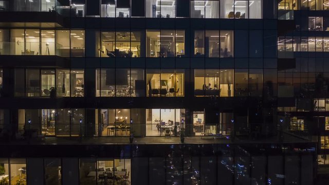 [Hyper Lapse] Workers at office building at night, view trough a window, 4k aerial drone timelapse 