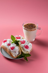 Air cake with raspberries on a saucer. Kefir with cinnamon, fermented drink. Pink background