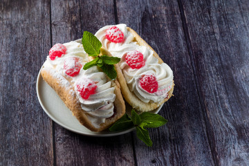 Airy raspberry cake in a plate on a wooden background