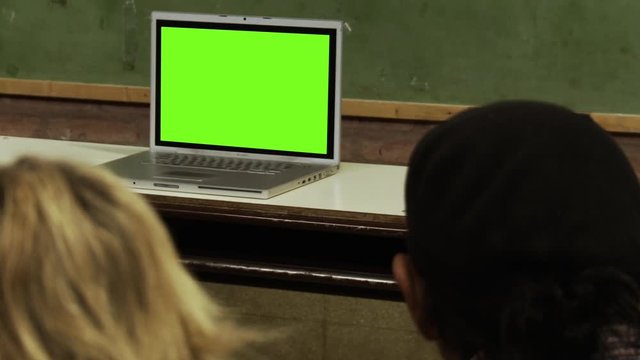 People Sitting at School and Watching a Laptop with Green Screen. You can replace green screen with the footage or picture you want. You can do it with “Keying” effect in After Effects.