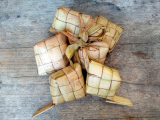 Ketupat or Rice Dumpling On Wooden Background. Ketupat is a natural rice casing made from young coconut leaves for cooking rice during eid Mubarak, Idul Fitri or Aidilfitri