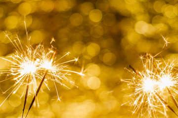 close-up of burning sparklers on beautiful bokeh background, christmas and new year festive concept