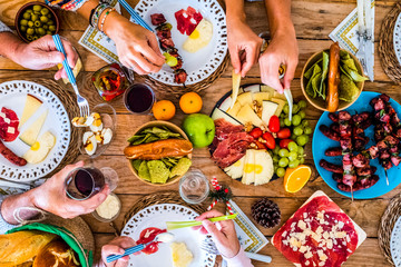 Above view of table full of coloured food for dinner or lunch activity concept - family caucasian people enjoying celebate together at home -winter chistmas decorations and fun