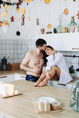 couple in the kitchen with christmas decoration, drink sparkling wine, celebrate christmas