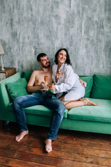 couple celebrating new year, green sofa, cozy at home