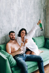 couple celebrating new year, green sofa, cozy at home