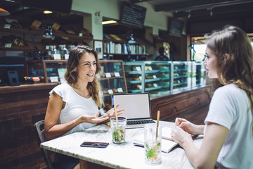 Adult woman explaining material to young female student