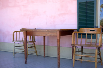 Table and chairs next to pink wall on patio