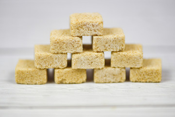Stacked of brown sugar cubes on table background - Close up sugar