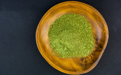 Coarse grind Mitragynina speciosa or Kratom powder in wooden bowl