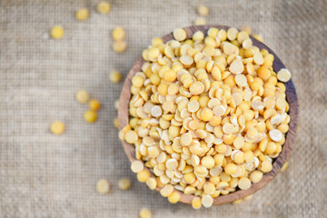 Soybean in a wooden bowl agricultural products on the sack background - Peeled Split Soybean or Soya Bean without husk