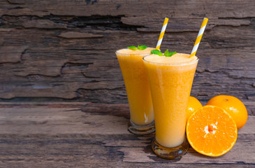 Orange juice fruit smoothies yogurt drink yellow healthy delicious taste in a glass slush for weight loss on wooden background.