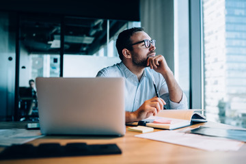 Thinking man making notes in office