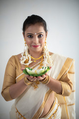 Portrait of an young and attractive Indian  woman in white traditional wear with colorful flowers...