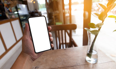 Mockup image blank white screen cell phone.men hand holding texting using mobile on desk at home office. background empty space for advertise text.people contact marketing business and technology 