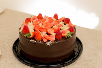 Delicioso bolo de chocolate coberto com muitos morangos cortados. Conceito de festa. Foco seletivo.