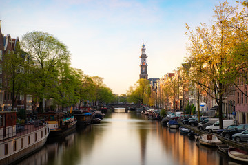 Fototapeta na wymiar Canals of Amsterdam during sunset in Netherlands. Amsterdam is the capital and most populous city of the Netherlands. Landscape and culture travel, or historical building and sightseeing concept.