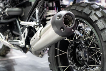 Close-up of exhaust or Intake of black sport racing Motorcycle with new tire and wheel in showroom. Low Angle Photograph Of Motorcycle..