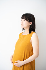マタニティドレスを着た妊婦（白背景）