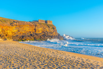 Lighthouse above North beach at Nazare, Portugal
