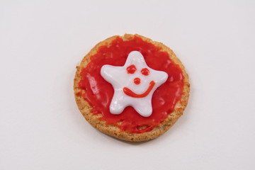 Christmas cookie decorated with royal icing sugar. Cookie decorated with red color and white star on it. Christmas cookie icing.  White background. Selective focus