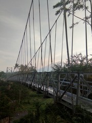 Suspension bridge over the river with steel construction